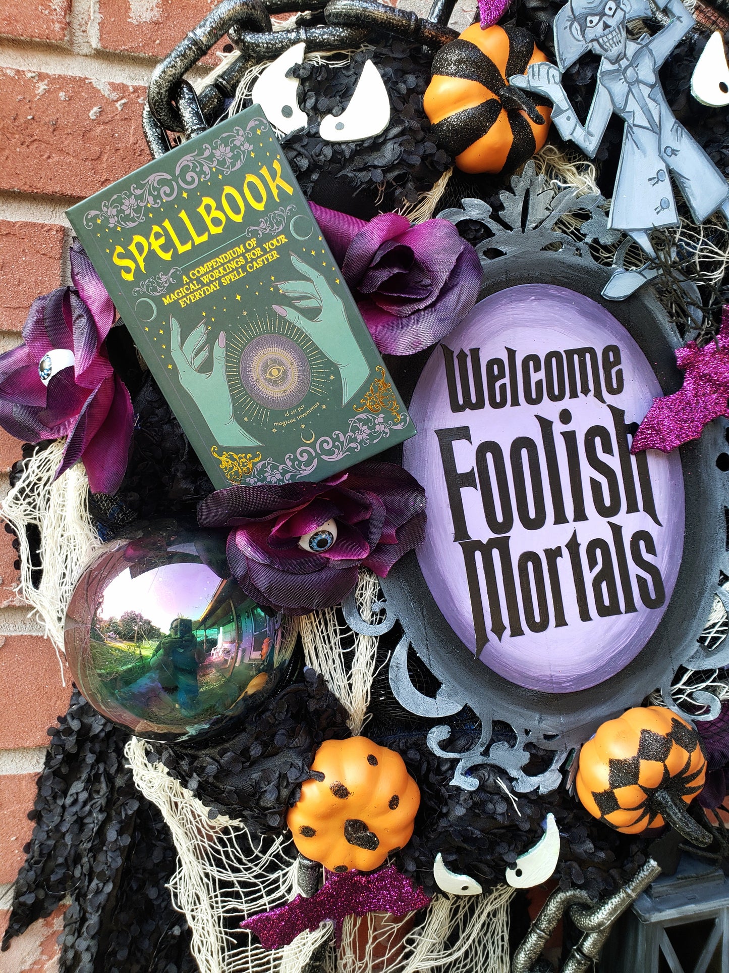 Haunted Mansion wreath with hitchhiking ghosts, madame Leota, welcome Foolish Mortals and glow in the dark eyes 