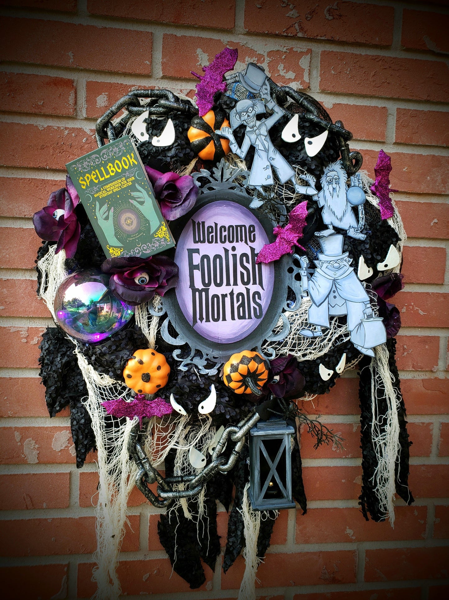 Haunted Mansion wreath with hitchhiking ghosts, madame Leota, welcome Foolish Mortals and glow in the dark eyes 