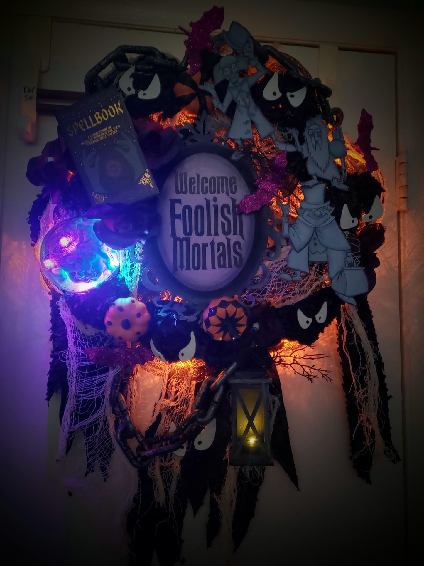 Haunted Mansion wreath with hitchhiking ghosts, madame Leota, welcome Foolish Mortals and glow in the dark eyes 